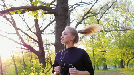 Jogging-In-The-Forest-On-The-Background-Of-The-Setting-Sun-An-Attractive-Woman-Running-In-The-Sun-Sl