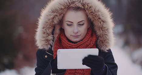 Female-Tourist-Using-Digital-Tablet-In-Forest-In-Winter-1