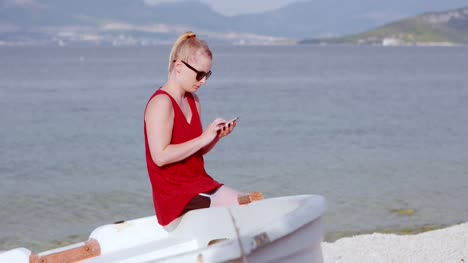 Junge-Dame,-Die-Am-Strand-Sitzt,-Während-Sie-Ihr-Mobilgerät-Benutzt-10