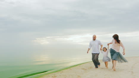 Family-Fun-Mom-Dad-And-Daughter-Run-On-The-Beach