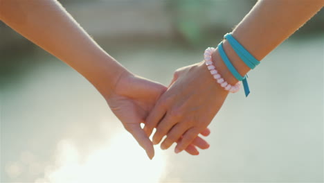 Two-Woman-Tenderly-Hold-Hands-Romantic-Couple