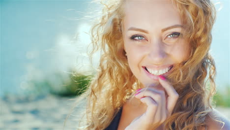 Close-Up-Of-A-Beautiful-Young-Woman-Smiling-At-The-Camera-Sunny-Day-At-The-Beach-Near-The-Sea