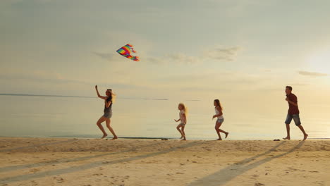 Group-Of-Children-Playing-With-Adults-Let-Them-Into-The-Sky-Kite-Fun-Running-On-The-Beach