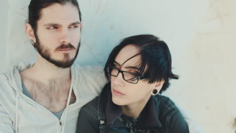 Thoughtful-Young-Hipster-Couple-They-Sit-Side-By-Side-On-The-Windowsill-Dream-Dark-Haired-Woman-With