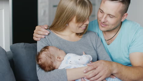 Portrait-Of-A-Young-Happy-Family-At-Home-Father-Mother-And-Baby