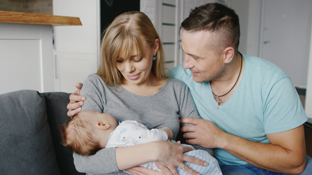 Premium stock video - Happy family with a baby at home mother father and  son two months concept - marital happiness the co