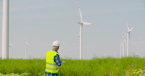 Ingenieur-Mit-Digitalem-Tablet-Während-Der-Inspektion-Von-Windkraftanlagen-Im-Windmühlenpark