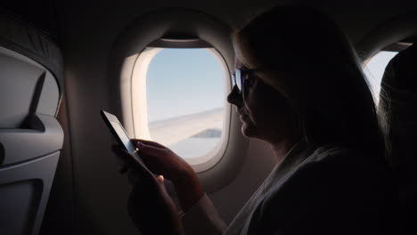 Business-Woman-Reads-An-E-Book-In-The-Plane-Business-Trip-Concept