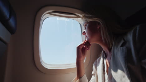 Business-Woman-With-Glasses-Flying-In-An-Airplane-Looking-Out-The-Window