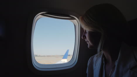 A-Young-Woman-Looks-Out-The-Window-Of-The-Plane-Which-Begins-To-Accelerate-Along-The-Runway-Start-Of