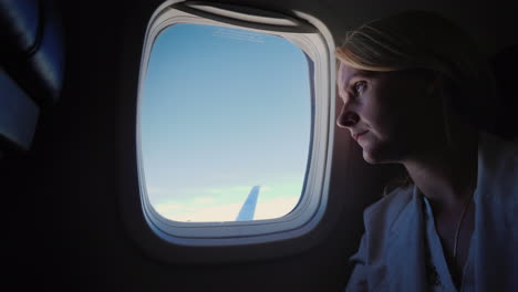 Lonely-Sad-Woman-Looks-Out-The-Porthole-Of-The-Plane