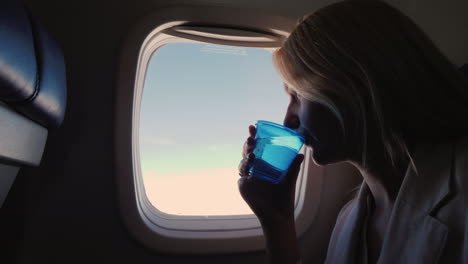 A-Female-Passenger-Airliner-Drinks-Water-From-A-Plastic-Cup
