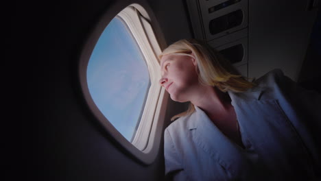 Young-Caucasian-Woman-Traveling-In-An-Airplane-Looking-Out-The-Window