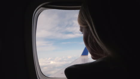 Woman-Flying-In-An-Airplane-Looking-Out-The-Window