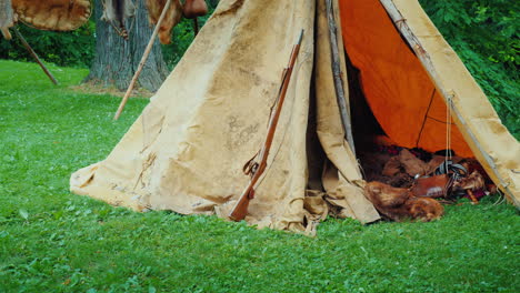 An-Old-Hunter's-Tent-In-The-Forest-In-It-Lie-Animal-Skins-And-Weapons-American-Pioneers