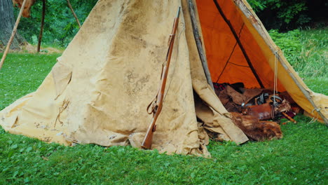 An-Old-Hunter's-Tent-In-The-Forest-In-It-Lie-Animal-Skins-And-Weapons-American-Pioneers
