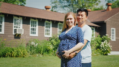 Young-Multi-Ethnic-Couple---Asian-Man-And-Pregnant-Caucasian-Woman-Are-Standing-In-Front-Of-Their-Ne