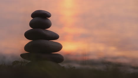 A-Hand-Lays-A-Stone-On-Top-Of-A-Tower-Of-Stones-Harmony-And-Balance-Concept