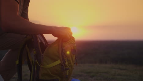 Ein-Mann-Packt-Bei-Sonnenuntergang-Seinen-Rucksack-Und-Bereitet-Sich-Auf-Eine-Reise-Oder-Ein-Trekking-4k-10-Bit-Video-Vor