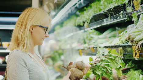 Young-Woman-Picks-Beets-In-The-Vegetable-Department-Of-The-Store