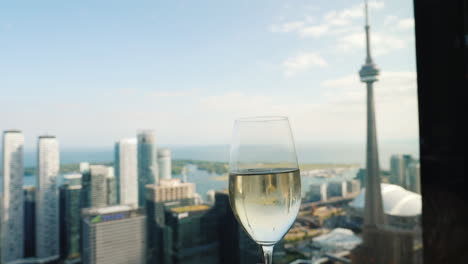 Heben-Sie-Ein-Glas-Champagner-Am-Fenster-An,-Von-Dem-Aus-Sie-Den-Berühmten-Cn-Turm-Sehen-Können---Ein-Symbol-Von-Toronto