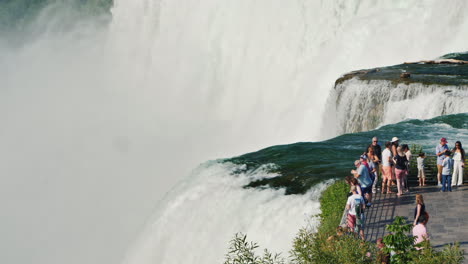 Tourists-On-The-Observation-Deck-Stand-Against-The-Background-Of-A-Wall-From-The-Water-Of-Niagara-Fa