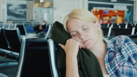 A-Young-Woman-Fell-Asleep-In-The-Airport-Terminal-Flight-Delay-Or-Cancellation-Concept