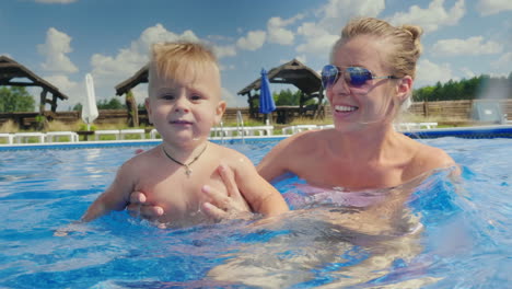 Mom-And-The-Baby-Boy-Swim-In-The-Pool-Have-Fun-Together