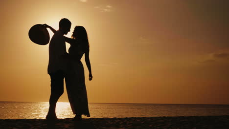 Silhouette-Eines-Verliebten-Paares,-Sie-Schauen-Sich-An,-Umarmen-und-Küssen-Sich-Bei-Sonnenuntergang-Vor-Dem-Hintergrund-O