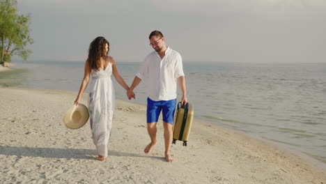 A-Loving-Couple-Is-Walking-Along-A-Tropical-Beach-Carry-A-Travel-Bag-Steadicam-Shot