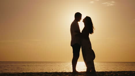 Romantisches-Junges-Paar,-Das-Sich-Bei-Sonnenuntergang-Gegen-Das-Meer-Küsst-4k-Zeitlupenvideo