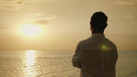 Lonely-Man-Looking-Forward-To-The-Sunset-Over-The-Sea-Back-View-Romance-And-Vacation-At-Sea