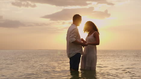 Young-Couple-In-Love-Standing-In-The-Sea-At-Sunset-Looking-At-Each-Other-Hd-Video