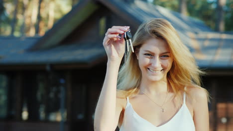 Young-Woman-With-Keys-From-Home-Smiling-Looking-At-The-Camera