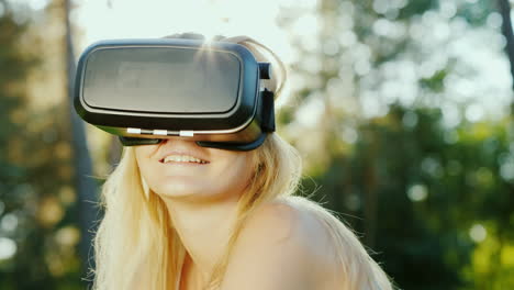 Attractive-Woman-In-A-Helmet-Of-Virtual-Reality-Sits-In-A-Beautiful-Place-On-The-Nature-Slow-Motion-