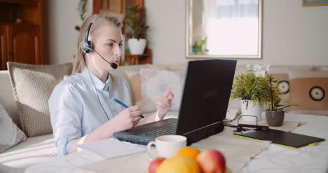 Sales-Representative-In-Headset-Speaking-To-Client-And-Making-Video-Conference-Call-On-Laptop-11