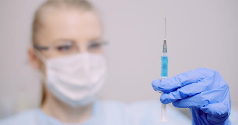Doctor-Holding-Syringe-In-Hands-3