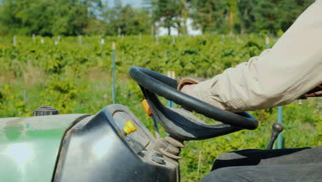 Farmer's-Hands-On-The-Wheel-Of-A-Tractor-Rides-Along-The-Vineyard