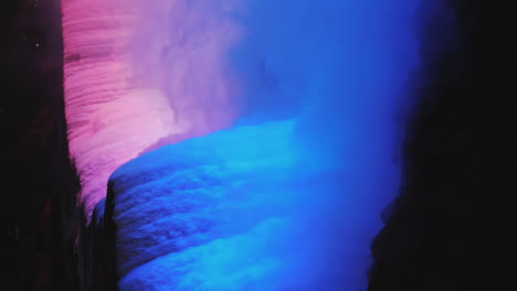 Vertikales-4k-Video---Nachtansicht-Von-Niagara-Fällen,-Die-Von-Einem-Blauen-Flutlicht-Beleuchtet-Werden