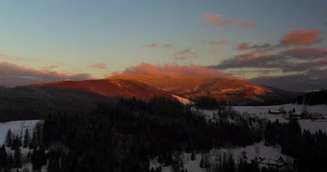 Luftaufnahme-Von-Schneebedeckten-Bergen-Und-Wäldern-Bei-Sonnenuntergang-Im-Winter-3