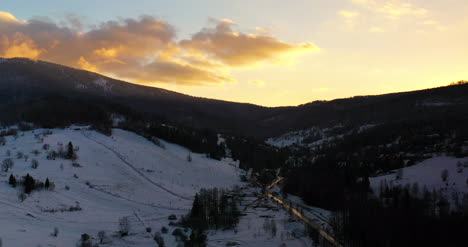 Luftaufnahme-Von-Schneebedeckten-Bergen-Und-Wäldern-Bei-Sonnenuntergang-Im-Winter-4