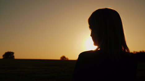 A-Thoughtful-Woman-Looks-At-The-Setting-Sun-The-Back-View-Dreams-And-Loneliness-Concept-Look-Forward