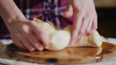 Close-Up---Hands-Knead-The-Dough-On-A-Wooden-Board-The-Board-Is-Oiled-With-Vegetable-Oil-4K-Video