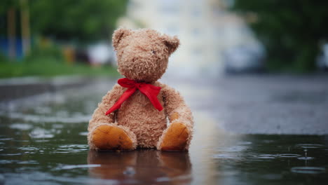 Einsamer-Teddybär-Sitzt-In-Einer-Pfütze-Im-Regen-4k-Video