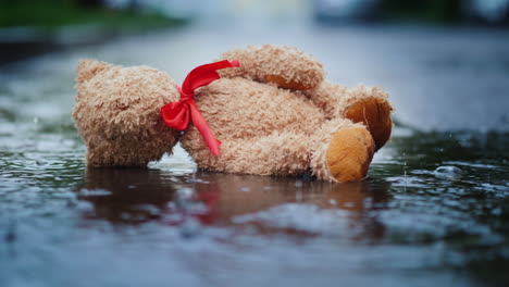 The-Abandoned-Little-Bear-Lies-On-A-Wet-Road-It\'s-Raining-Loss-And-Depression-Concept-4K-Video