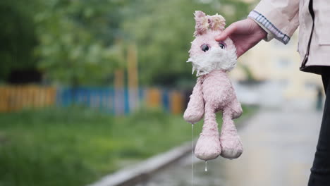 A-Woman-Is-Holding-A-Soaked-Toy-In-Her-Hand-Water-Drips-From-It-It\'s-Raining-4K-Video
