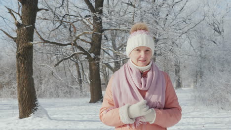 A-Middle-Aged-Woman-Is-Walking-In-A-Winter-Park-On-A-Clear-Day-It\'s-Snowing-4K-Slow-Motion-Video