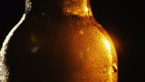 Nahaufnahme-Einer-Glasflasche-Mit-Kondenswasser-Kaltgetränkekonzept-Auf-Schwarzem-Hintergrund-4k