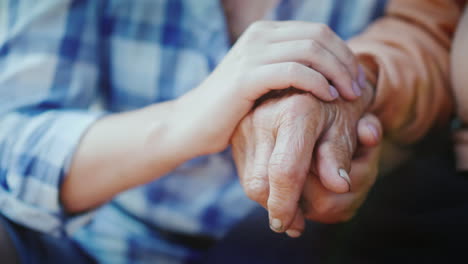 A-Young-Woman-Holds-An-Elderly-Lady's-Hand-Close-Up-Video