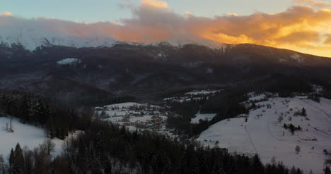 Luftaufnahme-Von-Schneebedeckten-Bergen-Und-Wäldern-Bei-Sonnenuntergang-Im-Winter-7
